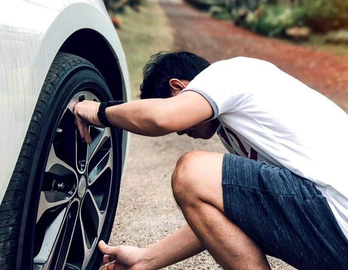 Man checking his car tyre